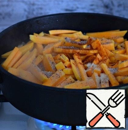 Then add the pumpkin, cut into large cubes, to the pan. Season with paprika, garlic powder, and salt. If desired, you can add a little ground black pepper. Stir.
During the entire cooking process, the fire is active.