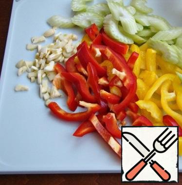 While the meat is stewing, prepare the vegetables: chop the bell pepper and celery into large strips. Chop the garlic into slices.