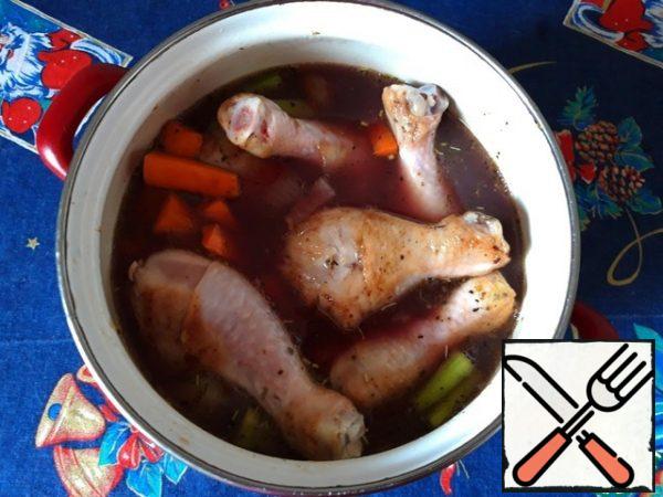 Put the chicken legs, bacon and vegetables in a saucepan with a thick bottom, add the broth and wine, put on the stove, bring to a boil, turn down the gas and simmer for about 40 minutes.