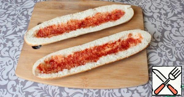I cut the baguette lengthwise into two parts. Removing the crumb.
I smear the inside of the baguette with ketchup.