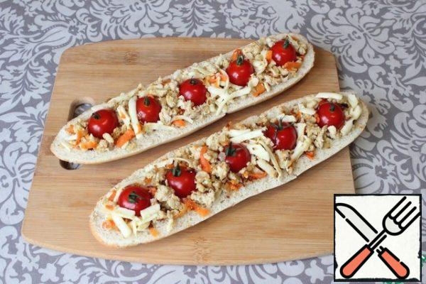 Fill the halves of the baguette with a filling of minced meat. I press cherry tomatoes into the filling (I got 5 cherries for each half of the baguette).