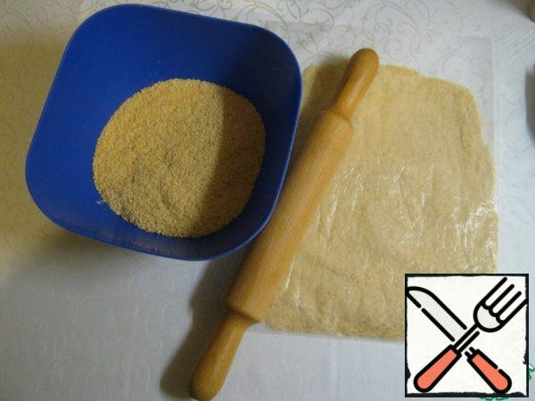 We will prepare all the necessary products. From the specified number of products, a cheesecake weighing 1 kg is obtained. We also need parchment paper and a split form. I have a form with a diameter of 22 cm. The larger the diameter of your mold, the lower the cheesecake will be. We take the most ordinary cookies. We grind it into very small crumbs, even into flour. For my taste, the best comes from cookies with the taste of melted milk.
So that your entire kitchen is not covered in crumbs, I advise you to do it in a file using a rolling pin. 280 gr. cookies I grind in this way in 3-4 approaches. If you have a blender with a bowl, you can grind it in a blender.