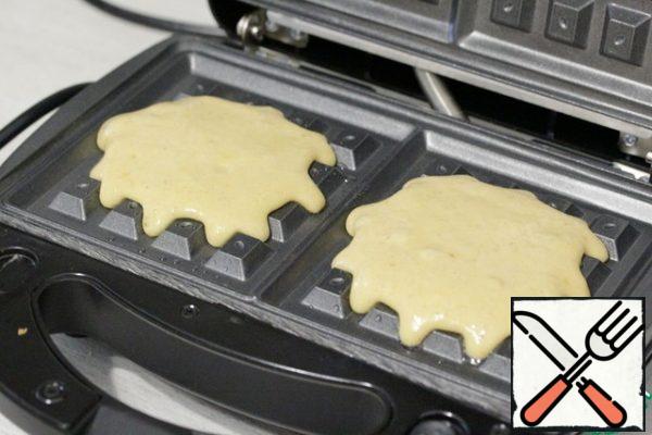 Lubricate the surface of the waffle iron with vegetable oil, pour the dough.