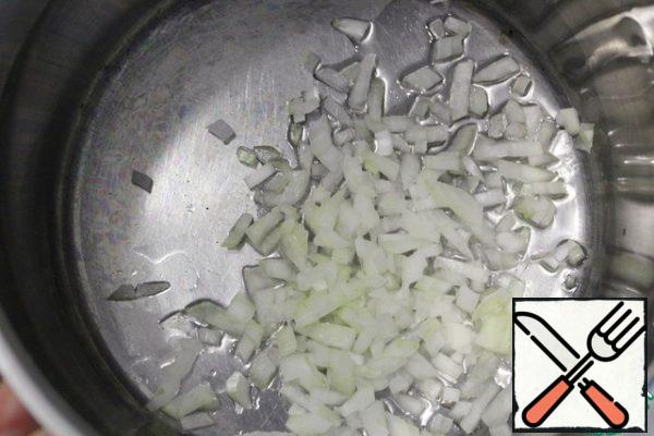 Pour a couple of tablespoons of vegetable oil into a saucepan with a thick bottom and heat it over medium heat. Add the onion and brown it.