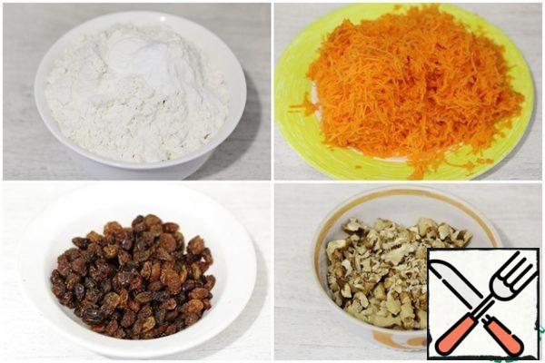 In a bowl, add the flour, baking soda and baking powder, and mix well.
Peel the carrots and grate them on a fine grater. The weight of already peeled carrots is indicated!
Wash the raisins and let the water drain.
Chop the nuts into small pieces.