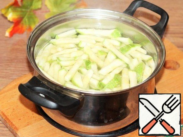 Cut the zucchini into strips and blanch in boiling water until half cooked. Then drain the water and dry the squash a little in a sieve.