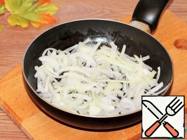 Peel the onion, carrot, and garlic. In a frying pan with a thick bottom pour the sunflower oil. In the preheated oil, fry until transparent: onion cut into half rings and garlic plates.