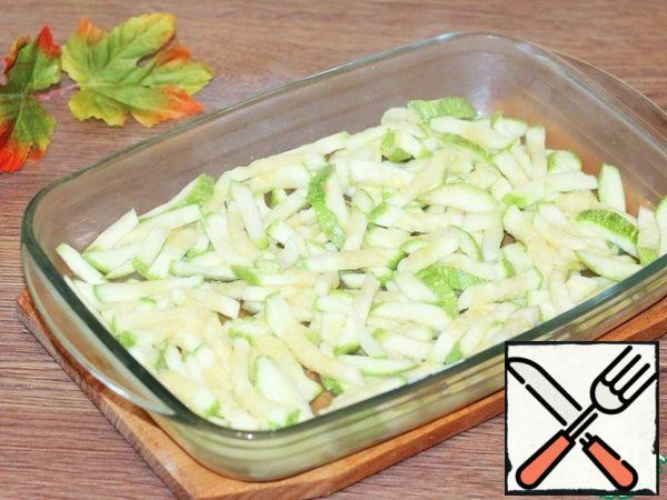 Grease the baking dish with sunflower oil and lay out the zucchini.