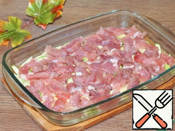 Cut the meat into small portion strips "for one bite" and spread evenly on the zucchini, sprinkle with seasoning for meat. Do not salt, because we have a salty roast, salty sauce and cheese. Seasoning also happens with the addition of salt.