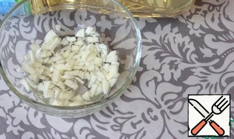I peel the garlic and chop it. In a bowl, mix the garlic and 2 tablespoons of sunflower oil.