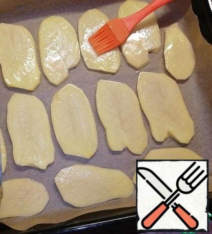 Cover the baking sheet with baking paper. Arrange the potatoes. Salt to taste. Brush with sunflower oil.