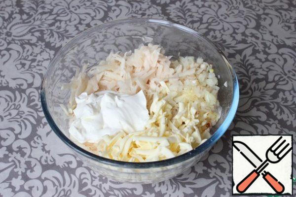 Potatoes quickly grate on a large grater. I put it in a deep bowl. I also RUB the processed cheese there. I put sour cream.
I add the chopped onion to the bowl, having previously fried it in a frying pan with the addition of sunflower oil.
Salt and pepper to taste. Stir.