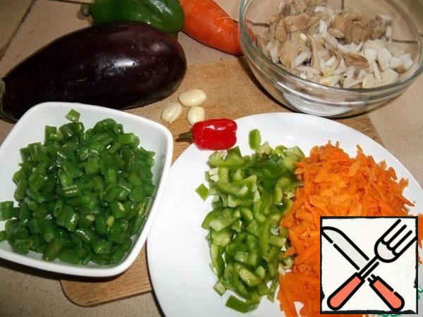 I have rice ready. Prepare vegetables and mushrooms. Grate the carrots on a coarse grater, finely chop the bell pepper and onion. String beans, cut into 1cm pieces, I boiled for 8 minutes in boiling water with a pinch of soda, then doused with cold water so that it does not lose its green color.