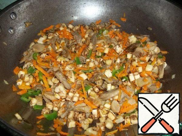 Then add the peeled and diced eggplant, freshly ground black and white pepper, and salt. Salt will give juice to the vegetables, which does not require the addition of liquid. Cook, stirring frequently. When the eggplant is almost ready, add the soy sauce and string beans.