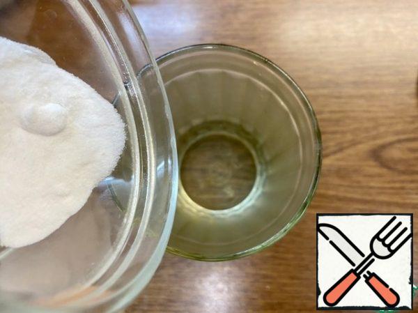 Boil water, pour about 30 ml into a glass, pour soda into boiling water and stir quickly, immediately pour the mass into the dough, stirring with a whisk.