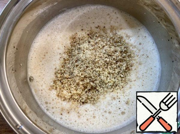 Add sunflower oil to the dough and stir with a whisk. Add the chopped walnuts and baking powder and stir.