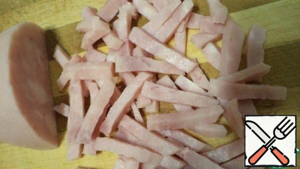 Cool the cabbage to a warm state.
Cut the ham. Put the cabbage in salad bowls, sprinkle with ham, pepper and garnish with green onions.