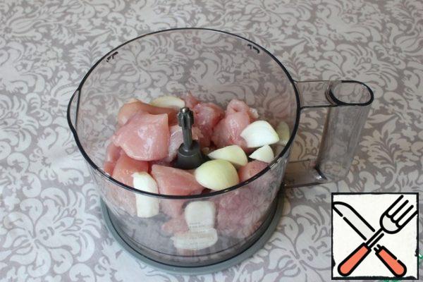 In the bowl of the blender, I put the chicken fillet, cutting it into large pieces. Add the peeled onion, also cutting it into pieces for convenience. I grind to a homogeneous state (the state of the cutlet mass).