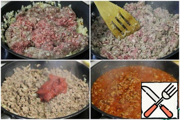 Put the minced meat in the pan, fry it, breaking the lumps with a spatula.
Add the tomato paste and fry, stirring.
Then pour in 200 ml of water, stir, bring to a boil and remove from heat.