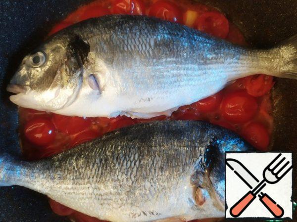 Put the fish on the tomatoes, wait a couple of minutes. Add the wine and boil it.