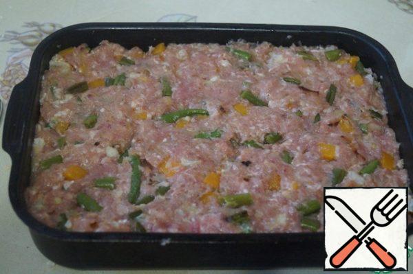 Combine the minced meat, vegetables and 2 eggs. Add salt and spices to taste. Mix well and put in a greased baking dish.