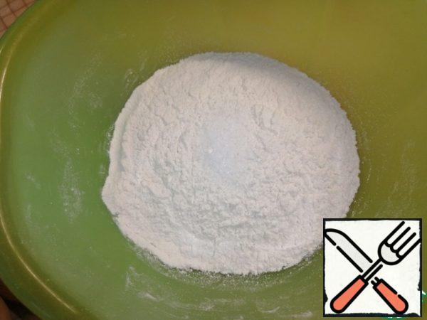 Sift the flour into a deep bowl. Add salt. Stir. Gradually pour in water at room temperature and knead the dough.