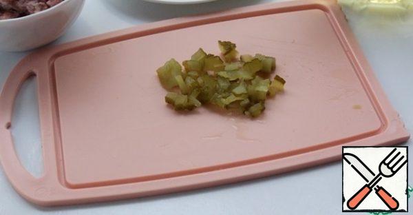 Finely chop the pickled cucumber. If the seeds are large, clean them with a spoon.
