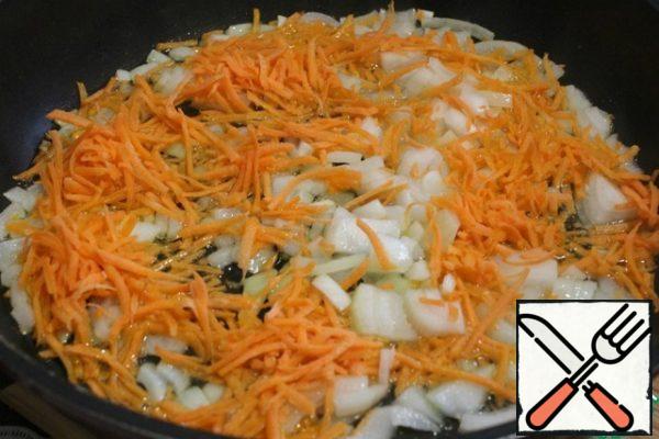 In a preheated frying pan with vegetable oil, fry the onion and carrots.
