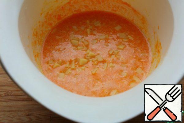 Add the flour and baking powder and mix.
Add the cheese cubes. Stir.