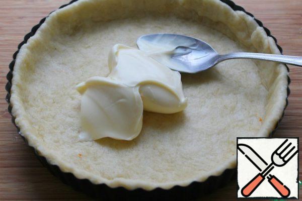 Spread an even layer of soft melted cheese on the dough.