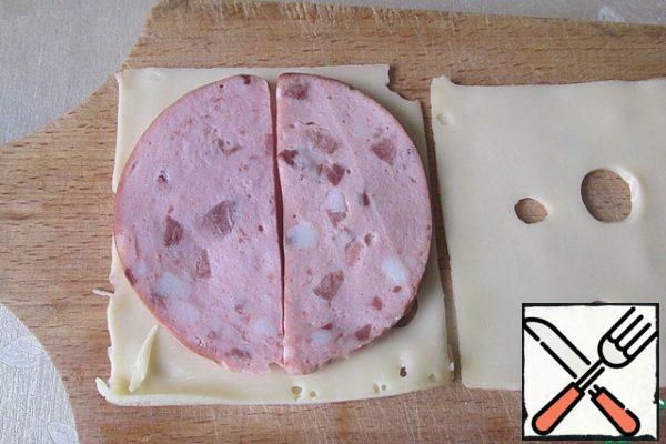 On the layer of cheese spread a layer, or circle, of boiled sausage or ham