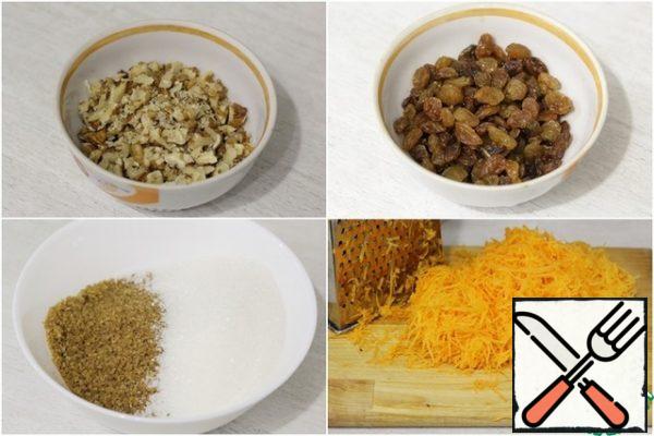 Chop the walnuts into pieces.
Wash and dry the raisins.
Peel the carrots and grate them on a fine grater.
Measure out the white and brown sugar (you can reduce the amount of sugar, but do not overdo it, otherwise the quality of the finished product will suffer).