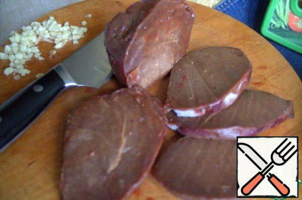 Slightly thawed liver is well cut into slices.