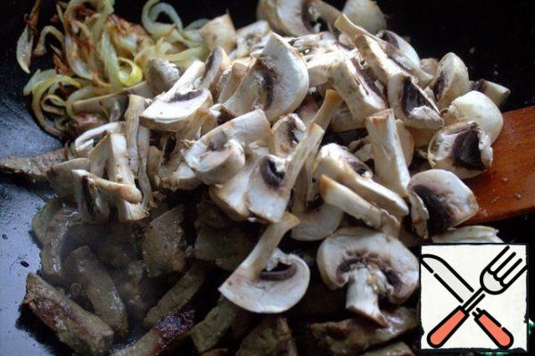 When the liver is fried, pour the mushrooms into the pan.