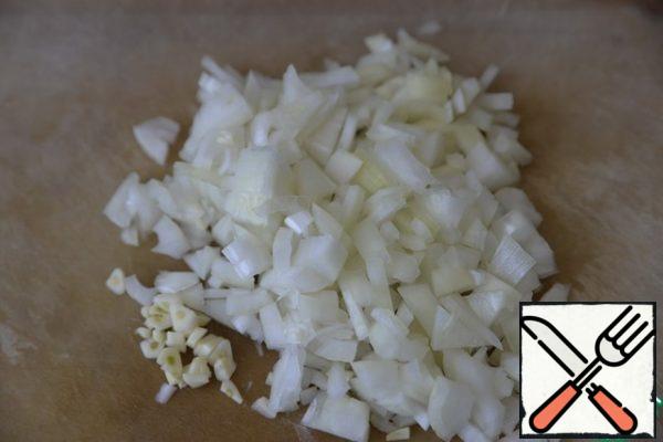 Peel the onion and garlic, cut the onion into cubes, chop the garlic.