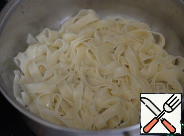 When ready, we throw the pasta in a colander, then put it in a saucepan, add oil, sunflower oil with the addition of olive oil, mix so that the paste does not stick together.