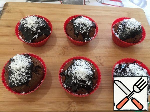 Ready-made cupcakes are coated with icing on top. And sprinkle with coconut shavings.