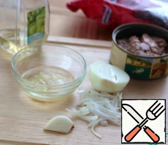It remains to thinly slice the onion, tear the green lettuce leaves with your hands and make the dressing. With canned food, drain 3 tbsp. l. oil, crush a clove of garlic and finely chop, add it to the oil, pour 1-2 tbsp. l. wine vinegar, mix well.
I have Peking cabbage leaves instead of lettuce.