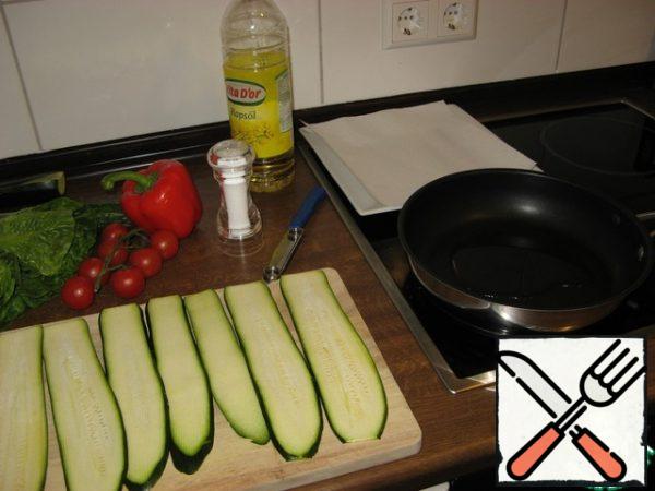 First, prepare the zucchini. Cut them into thin layers. Lightly salt and fry in oil for just a minute, not forgetting to turn once. We need the zucchini to become slightly soft, but not soft.
Put them on a paper napkin and set aside.