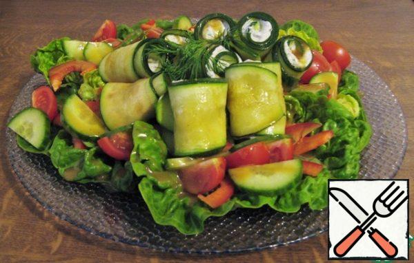 We spread a little filling on the edge of the zucchini, wrap it in a roll and randomly distribute it on our basis.