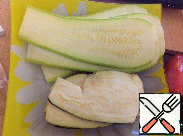Cut eggplant and zucchini into thin strips. We put them in two separate piles for convenience.