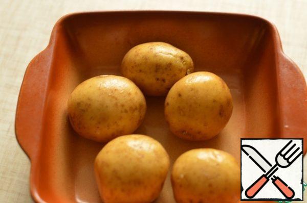 Wash the potatoes and bake in the oven until soft.