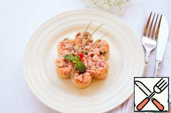 We take out the tar-tar from the refrigerator.
Then lay out a layer of Tartar and shape the salad. Place for 20-30 minutes in the refrigerator, covered with cling film. Next, remove the molding ring and decorate the tat-tar as desired.