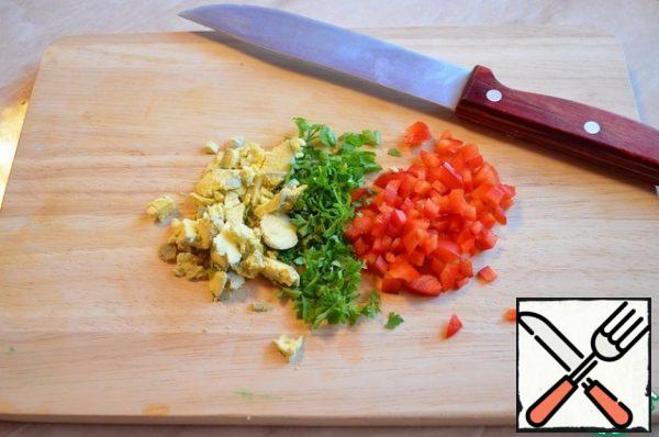 Finely chop the greens, cut into small cubes of red sweet pepper, chop the yolk of a boiled egg.