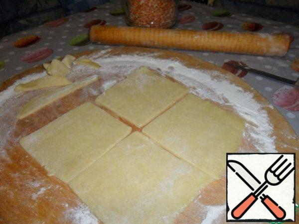 Roll out the dough, cut it into squares and put it in molds, greased with oil.
