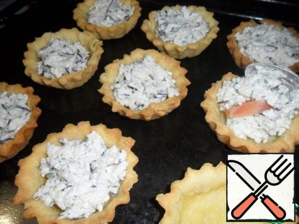 Put a little filling on the baked base, put a piece of salmon fillet, and a little more filling on top.