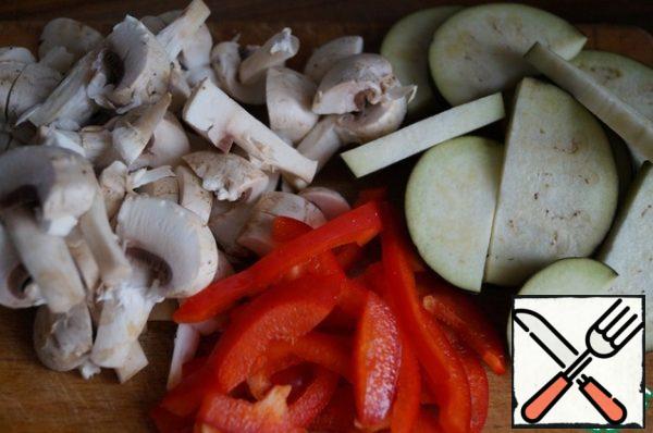 Cut half of the medium-sized eggplant and mushrooms into slices. Pepper cut into strips.