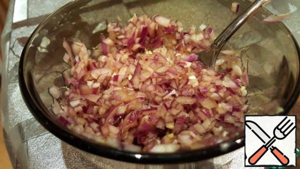 Finely chop the red onion. For one can of beans, you will need about half a small onion. Pour the soy sauce over the onion and leave to marinate.
