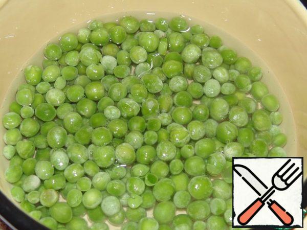 Boil the frozen green peas in a small amount of salt water. Such peas are more tender and sweet than canned.