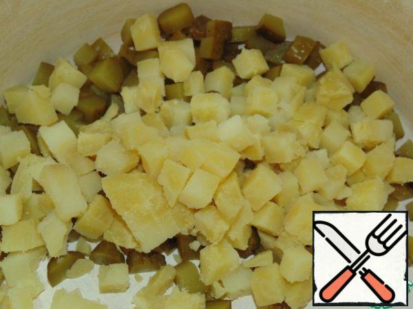 Cut the pickled cucumbers into cubes. Peel the cooled potatoes and cut into cubes.